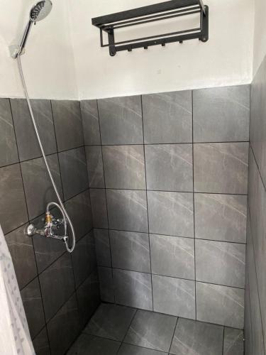 een badkamer met een douche met een douchekop bij Chez Bibi 
