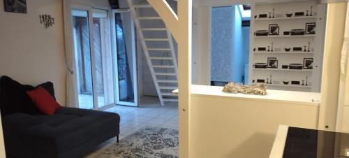 een woonkamer met een bank en een trap bij Appart cosy Disney paris in Chalifert