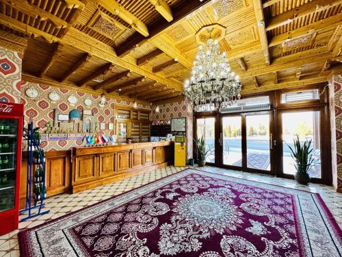 a large kitchen with a chandelier and a large rug at Zilol Baxt Hotel in Samarkand
