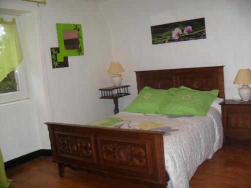 um quarto com uma cama de madeira e lençóis verdes em Gite de Peche em Saint-Ellier-du-Maine
