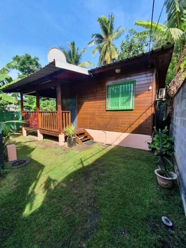 ein kleines Haus mit einer Veranda und einem Hof in der Unterkunft May'Nature in Labattoir