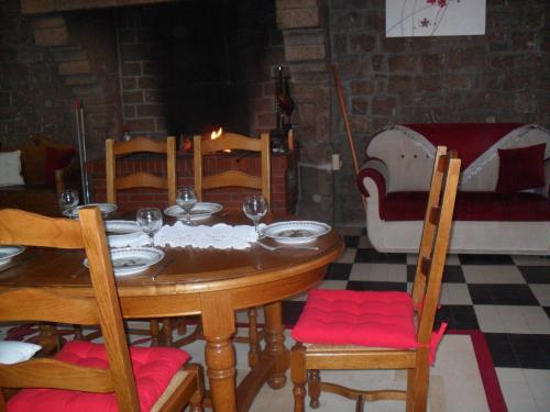 a wooden table with chairs and wine glasses on it at Gite de Peche in Saint-Ellier-du-Maine