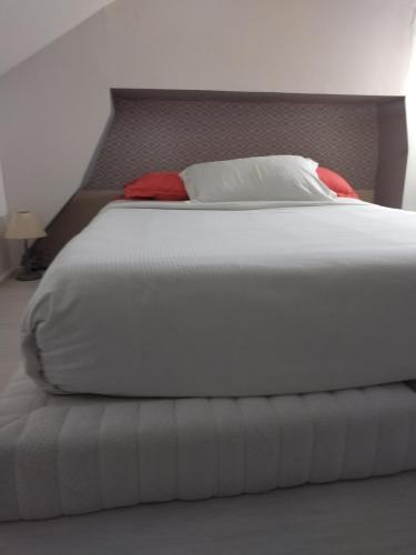 a bedroom with a white bed with a head board at Appart cosy Disney paris in Chalifert