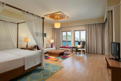 a bedroom with a bed and a living room at Xanadu Island in Akyarlar