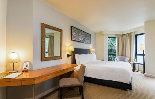 a hotel room with a bed and a desk at Chatrium Sathon Bangkok in Bangkok