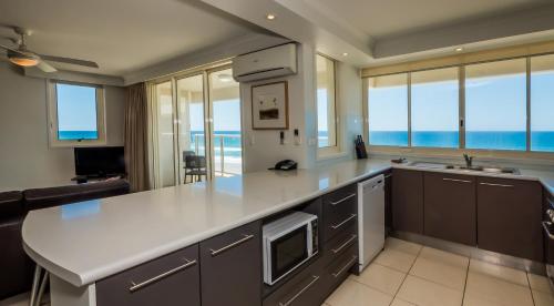 a kitchen with a large white counter top and some windows at Viscount on the Beach in Gold Coast