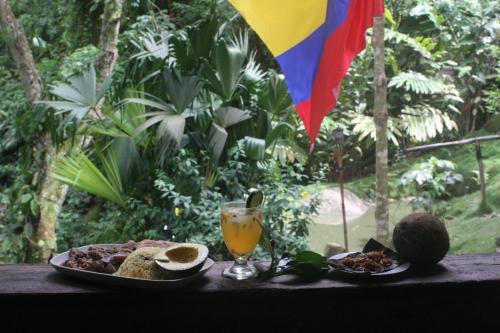 a table with a plate of food and a drink at La Cima Tayrona in Santa Marta