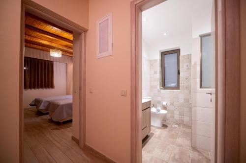 1 dormitorio con 1 cama y baño con aseo en Villas Chrysanthi, en Stoupa