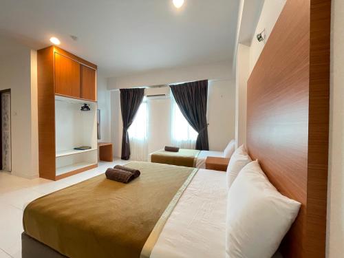 een slaapkamer met een groot bed met een houten hoofdeinde bij DZ Hotel Salor in Kota Bharu