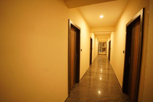 a hallway with two doors and a long corridor at Hotel Mangalore Stay INN in Mangalore