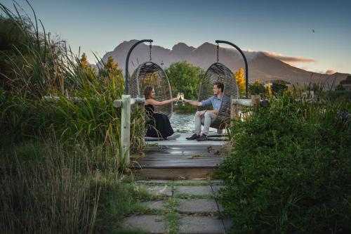a man and a woman sitting on a swing at Santé Wellness Retreat & Spa in Paarl