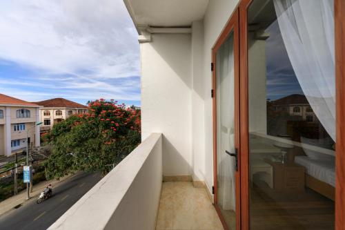 a door to a balcony with a view of a street at Golden Bee Hotel in Da Lat