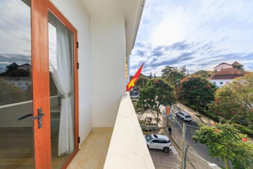 a flag on a balcony with a view of a street at Golden Bee Hotel in Da Lat