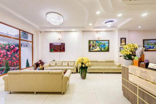 a waiting room with couches and flowers at Golden Bee Hotel in Da Lat