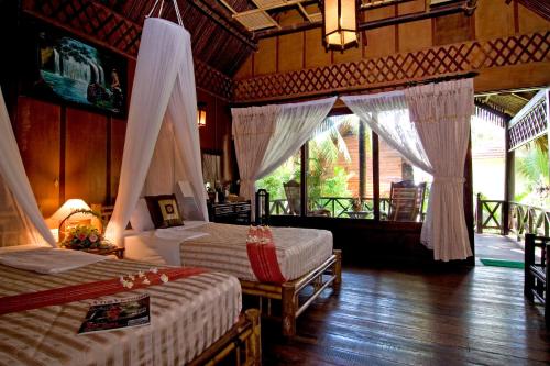 1 dormitorio con 2 camas en una habitación con cortinas en Ocean Star Resort, en Mui Ne