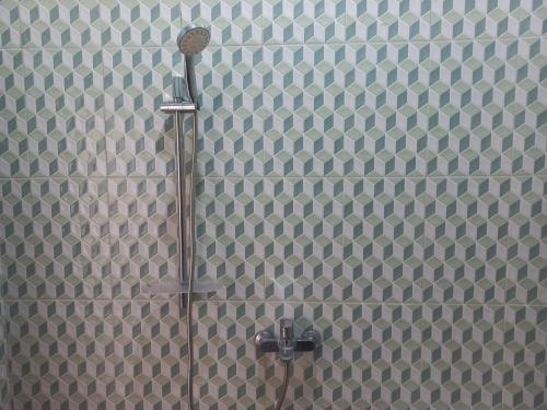 a shower with a shower head in a bathroom at Collection O 92242 Hotel Tanjung Emas in Purwokerto