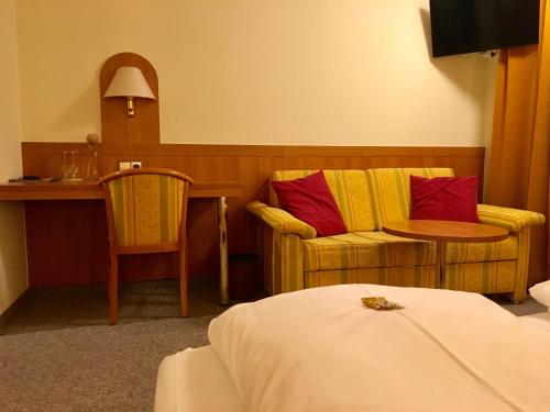 um quarto de hotel com uma cama, uma mesa e cadeiras em Hotel Engel em Ulm