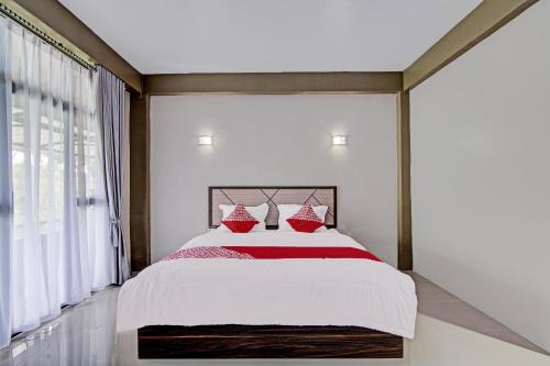 um quarto com uma cama grande e almofadas vermelhas em OYO 92247 Penginapan Thoybah Syariah 
