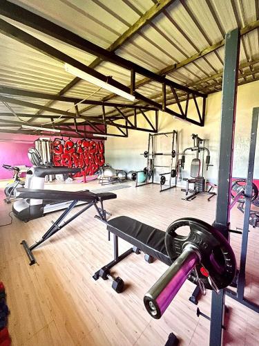 un gimnasio con varias cintas de correr y máquinas en él en JC ITEN Guest House, en Iten