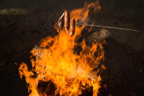 a fire with two hot dogs on top of it at Hotel Pasymowski in Mława