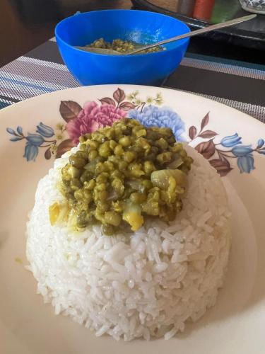 um prato de arroz com ervilhas em cima em JC ITEN Guest House em Iten