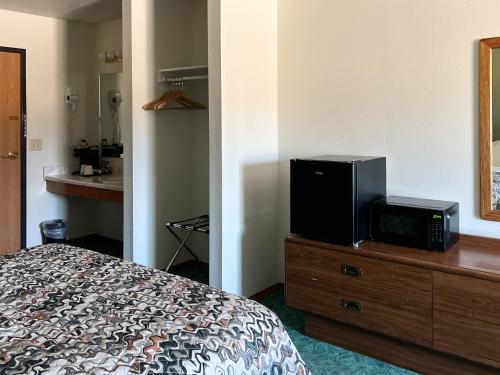 a bedroom with a bed and a television on a dresser at The Trail Inn - Sutton, Nebraska - US-6 HWY in Sutton
