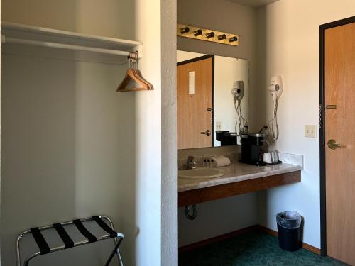 een badkamer met een wastafel en een spiegel bij The Trail Inn - Sutton, Nebraska - US-6 HWY 