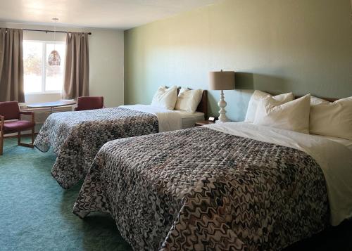 een hotelkamer met 2 bedden en een raam bij The Trail Inn - Sutton, Nebraska - US-6 HWY 