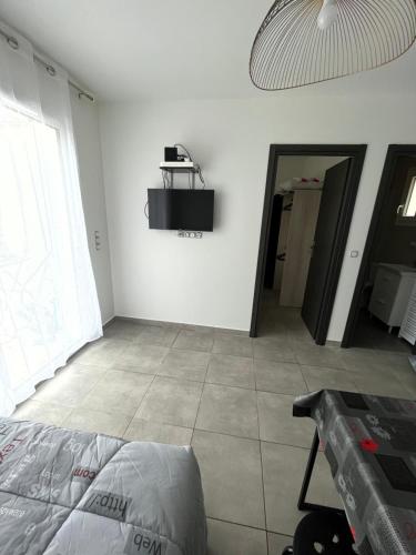 Cette chambre blanche comprend un lit et une table. dans l'établissement Maison T1 bis Corse, à Lucciana
