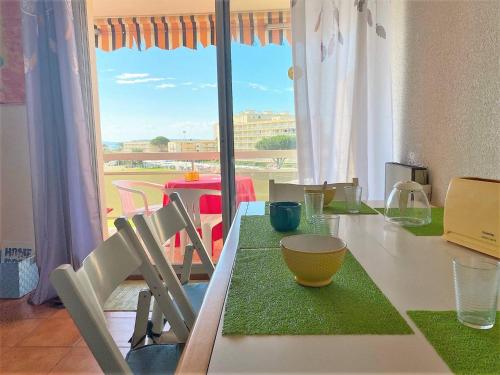 une table avec des chaises et une table avec une fenêtre dans l'établissement Studio au Lavandou, Proche Plage, Terrasse, Parking Privatif, 4 Couchages - FR-1-251-236, au Lavandou