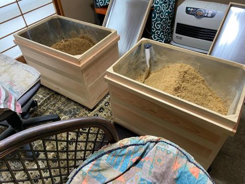 two containers of dirt sitting on the floor in a room at 田舎庵 in Hanyu