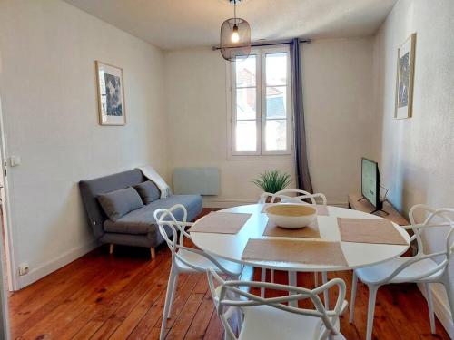 a living room with a table and chairs and a couch at T2 de charme, centre ville historique de Tarbes in Tarbes