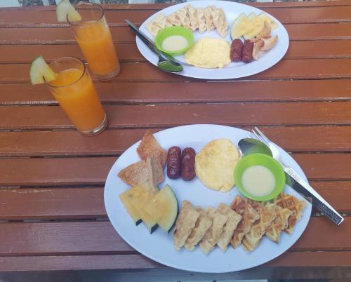 two plates of food on a wooden table with drinks at MilVir Tourist INN in El Nido