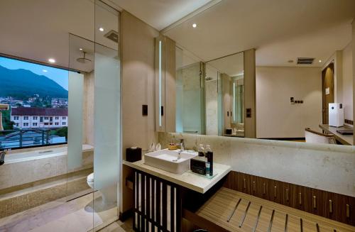 a bathroom with a sink and a large window at Golden Tulip Holland Resort Batu in Batu