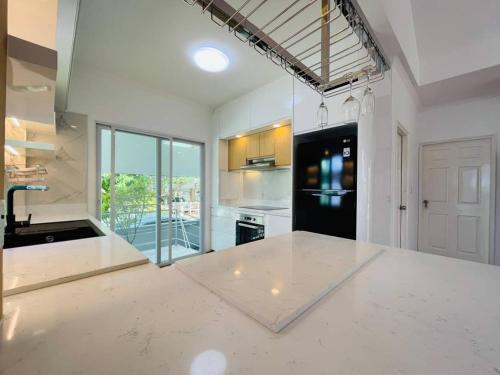 a kitchen with white counters and a black refrigerator at Private Pattaya Resort in Nong Prue