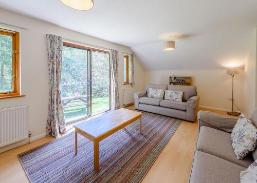 a living room with a couch and a table at Bulworthy Forest Lodges in Instow