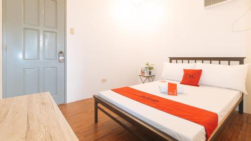 a bedroom with a bed with an orange and white blanket at Enrico's Place in Manila