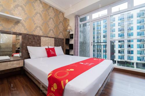 een slaapkamer met een groot bed en een groot raam bij RedLiving Apartemen Puri Orchard - Prop2GO Home Tower Magnolia in Jakarta