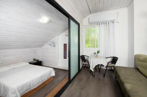 a bedroom with a bed and a table and chairs at Galilaeaen Loft in Chorazim