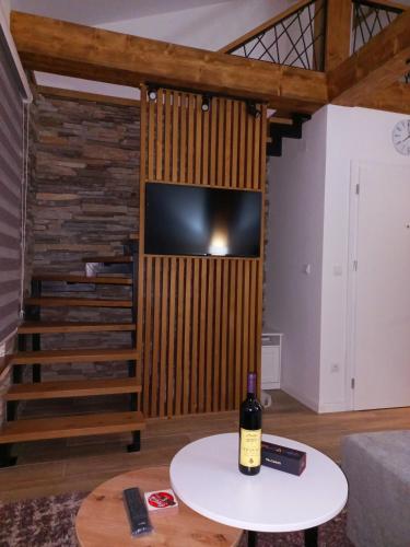 a living room with a tv and a table with a bottle of wine at White Eagle Kopaonik - Beli Orao in Kopaonik