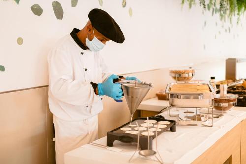 a man in a kitchen preparing food in a blender at Hotel Gran Sol in San Antonio