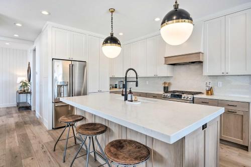 a kitchen with white cabinets and a large island with stools at Mountain-View Townhome Near Powder Mountain! in Huntsville