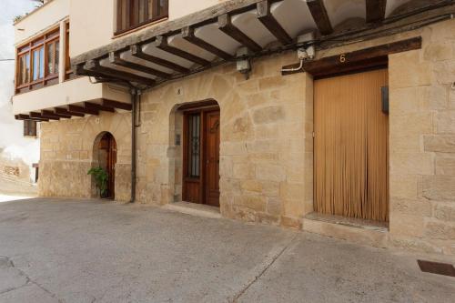 a stone building with a door and a garage at Apartamentos La Pastora in Peñarroya de Tastavins