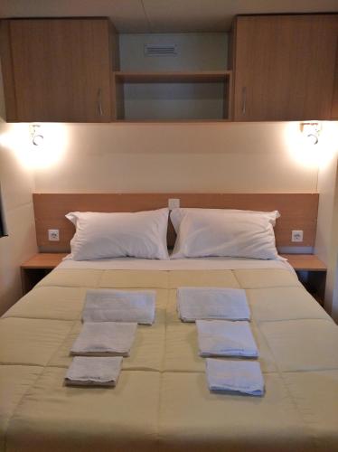 a large bed with three folded towels on it at Villaggio Turistico Il Lago Dorato in Carlazzo