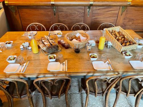 una mesa de madera con un montón de comida. en Château de Beauchamp- La chapelle de Guinchay, en La Chapelle-de-Guinchay