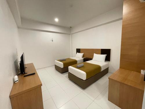 a hotel room with two beds and a television at DZ Hotel Salor in Kota Bharu