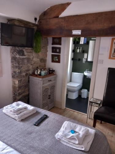 a bedroom with a bed and a bathroom with a toilet at The Pinfold in Skipton