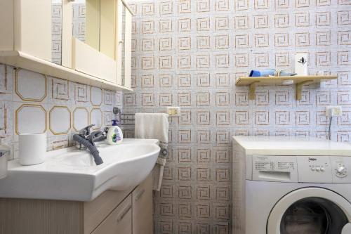 a bathroom with a sink and a washing machine at Villetta Il Gallo in Mazara del Vallo
