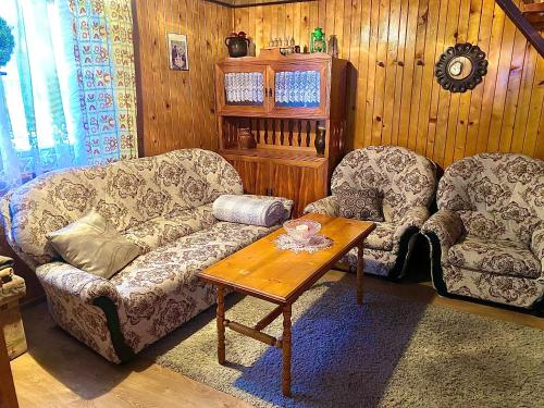 a living room with two chairs and a coffee table at Chatka Valaška in Terchová