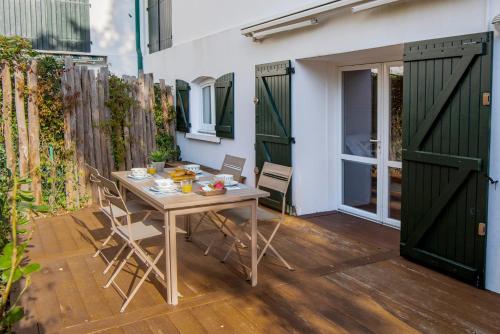un patio avec une table et des chaises et une clôture dans l'établissement Le Petit Bois - A 300m de la plage Pereire, à Arcachon